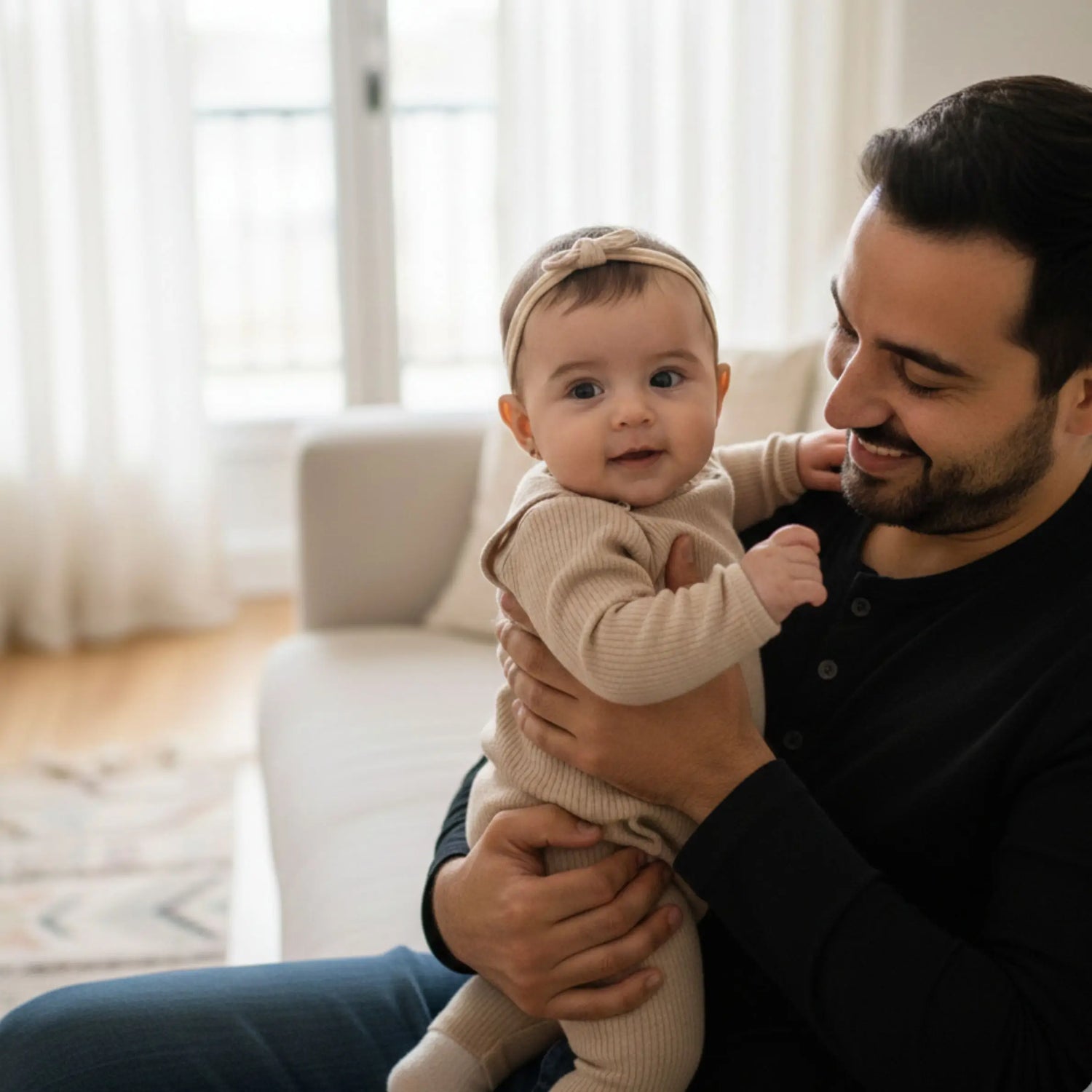 Man holding a baby in a living room setting