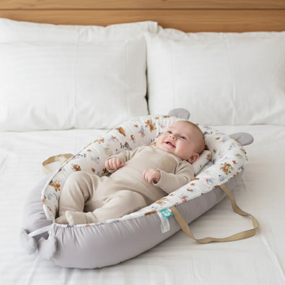 Baby lying in a portable crib on a bed