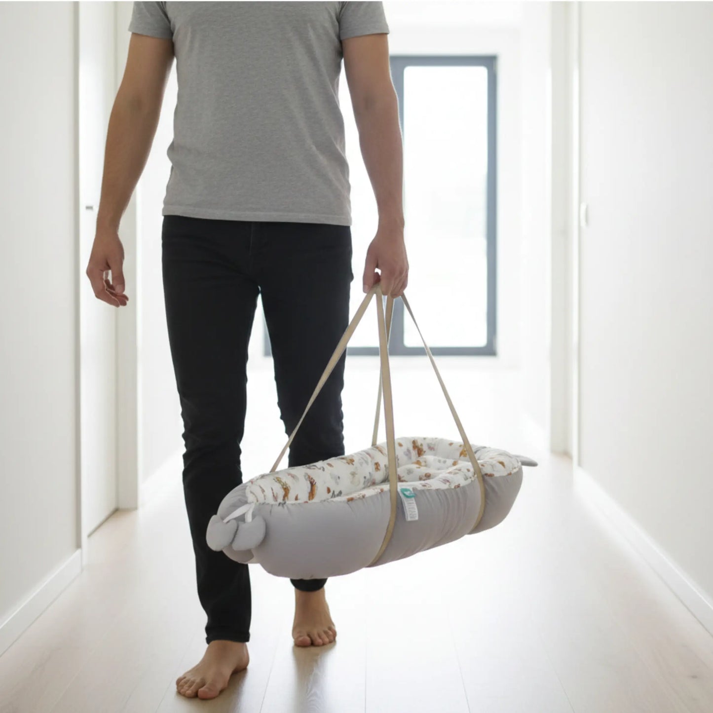 Person holding a baby swing in a minimalistic room