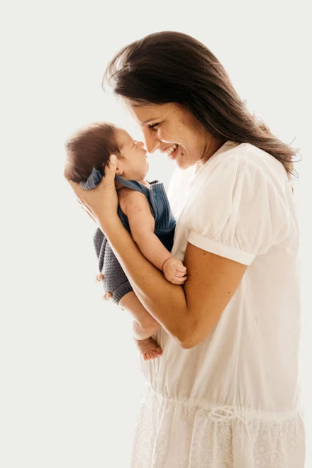Woman holding a baby against a white background