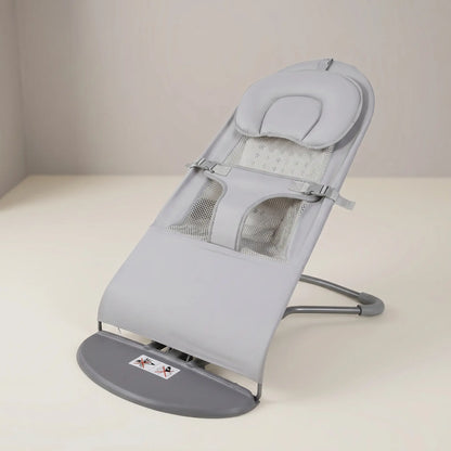 Gray baby bouncer on a white surface with a neutral background