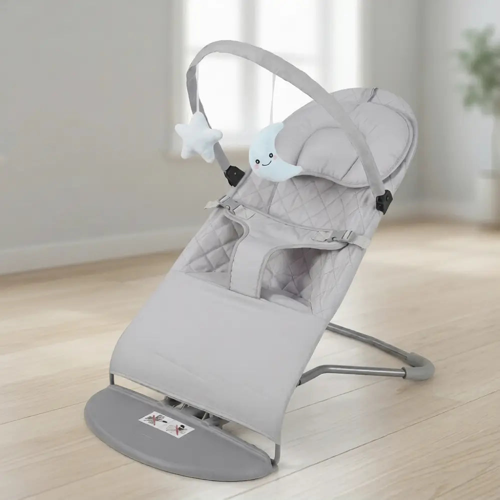 Gray baby bouncer on a wooden floor with a blurred background