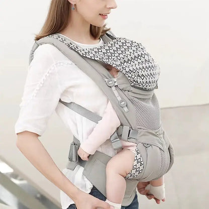 Woman using a gray baby carrier with a child inside on a light background