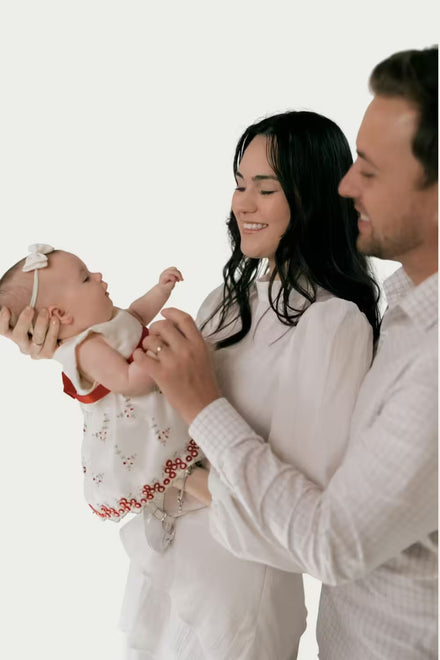 Family with a baby against a white background