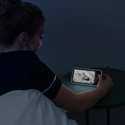 Person sitting in bed using a tablet in a dimly lit room