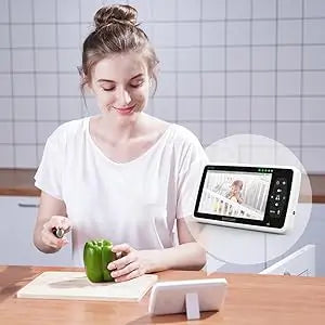 Woman in a kitchen using a tablet with a recipe displayed on the screen.